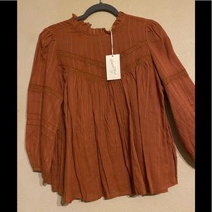 Light brown see-through blouse.